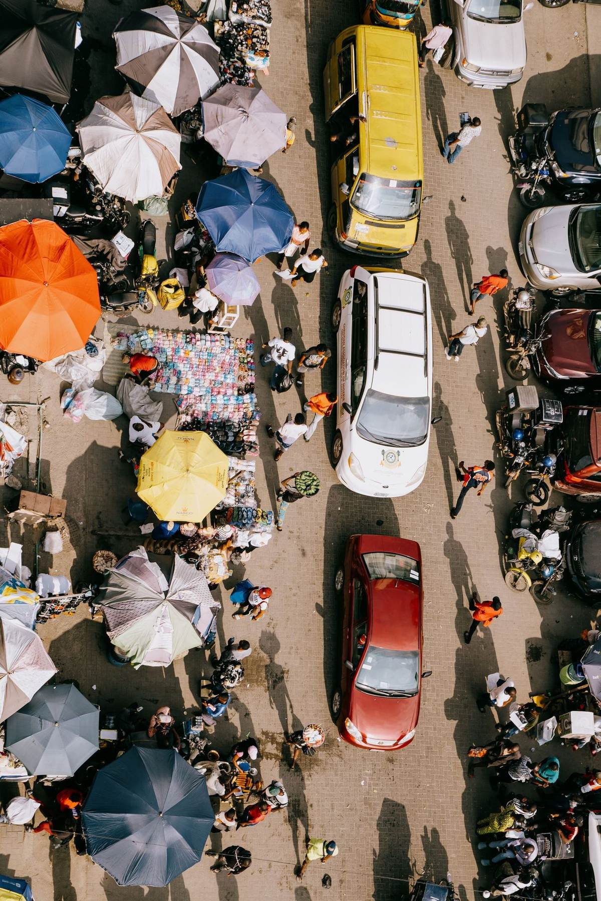 Overhead view of a busy street market, stalls and traffic side by side