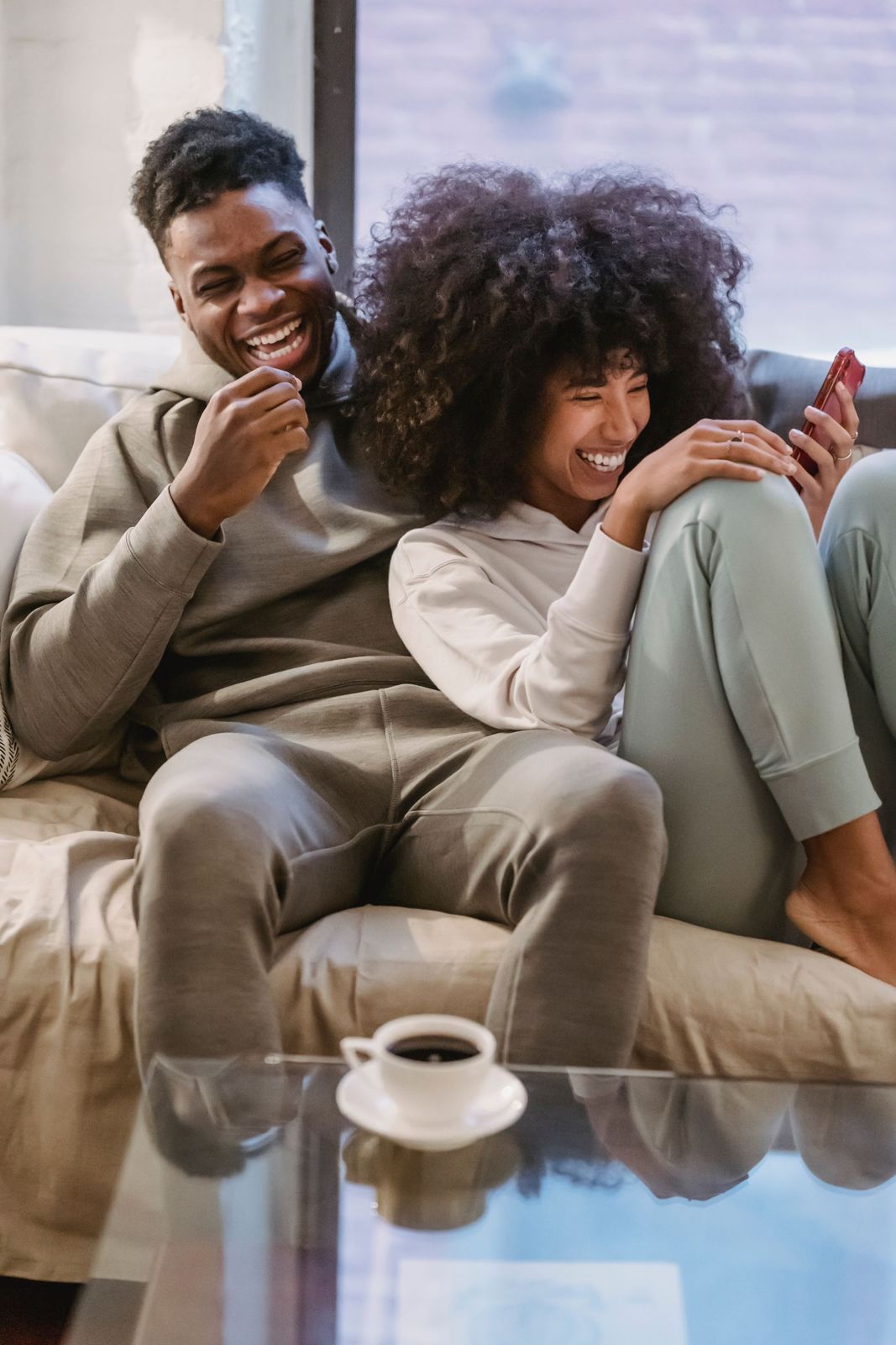 Couple laughing at a phone on the couch